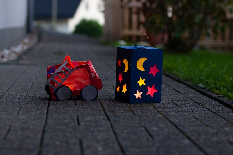 Selbstgebastelte Laternen stehen am Abend auf einem Weg