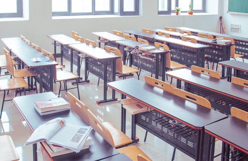 Ein heller Klassenraum mit Tischreihen