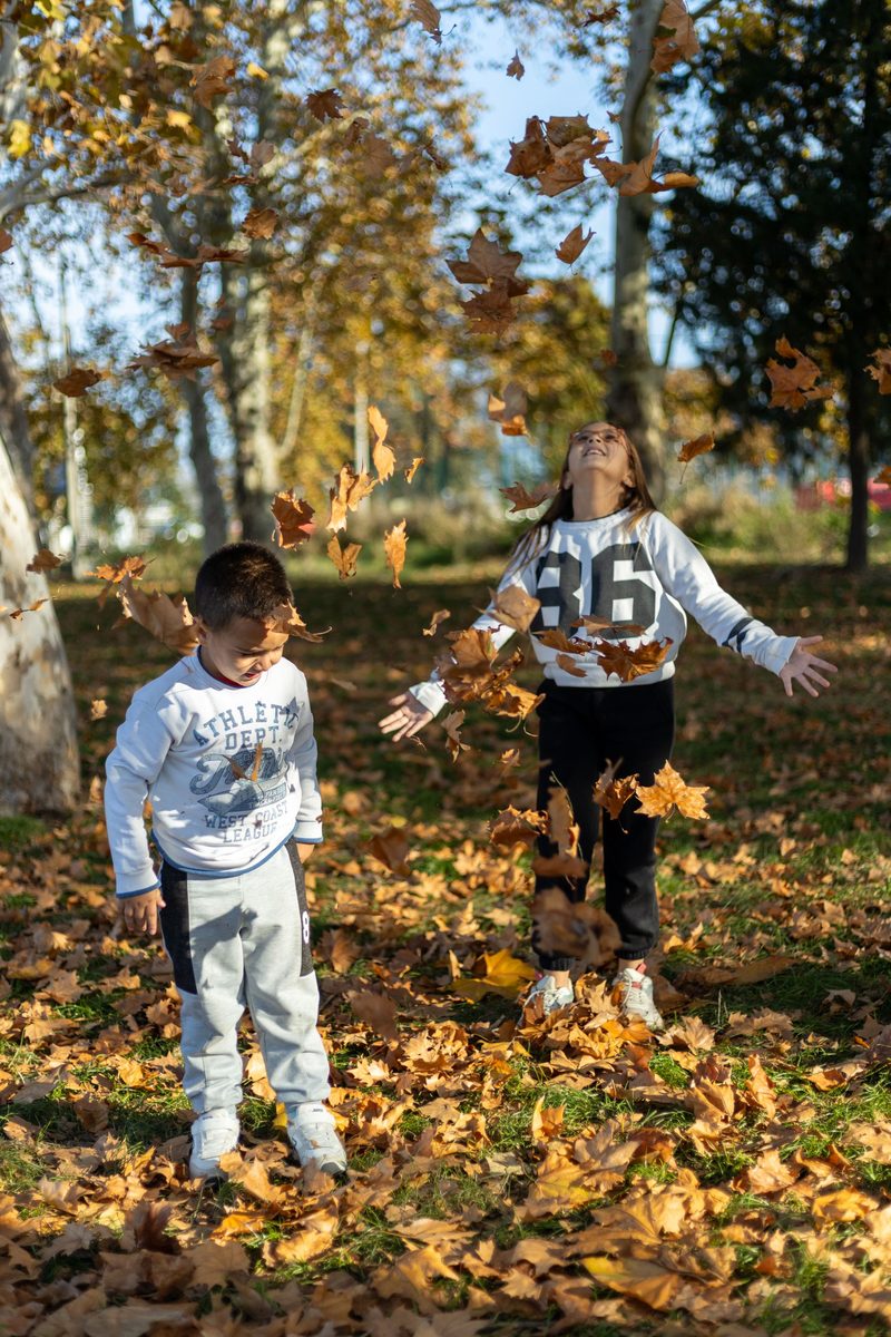 Zwei Kinder spielen im Herbstlaub